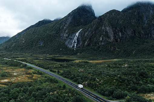 Scenic aerial view of camper van near waterfall on  road in Norway
