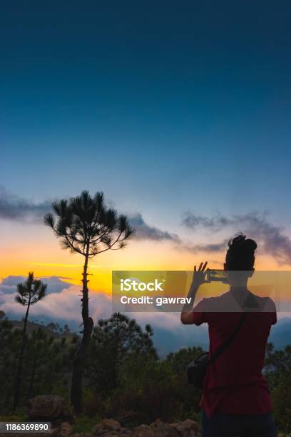 Woman Shoots Cloudy Sunset View In The Mountains Through A Smartphone Stock Photo - Download Image Now
