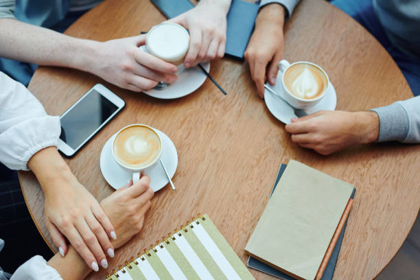 istock Hands of college students with gadgets and drinks gathered by table in cafe 1186374139
