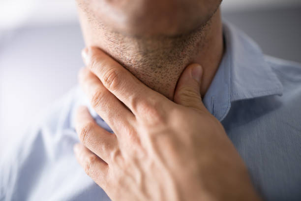 Close-up Of Male Suffering From Gland Inflammation Close-up Of A Man's Hand Touching His Sore Throat thyroid gland stock pictures, royalty-free photos & images