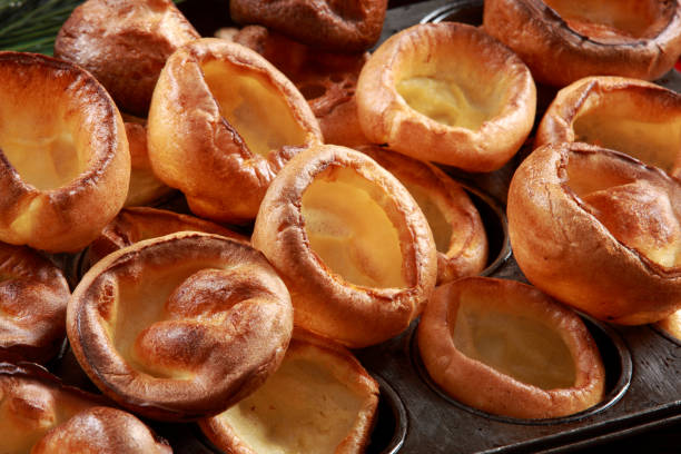 pudim de yorkshire na bandeja do cozimento com fundo festivo da madeira e decorativa - yorkshire pudding - fotografias e filmes do acervo