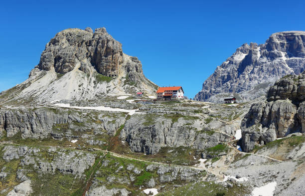 auronzo e abrigo da montanha de dolomites no parque nacional três picos de lavaredo, alpes de dolomites, italy - belluno veneto european alps lake - fotografias e filmes do acervo