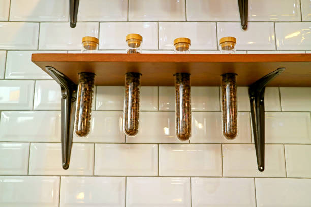 istock Coffee Bean Storage Glass Tubes Shelf on the White Tiled Wall 1186382666