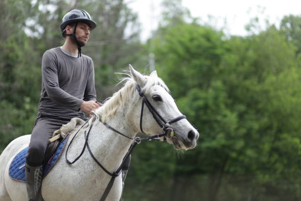 istock Young man is enjoying horseback riding in nature 1186382726
