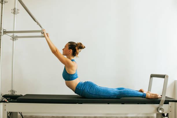 istock Woman performing Pilates exercise using a Cadillac or Trapeze table 1186382756