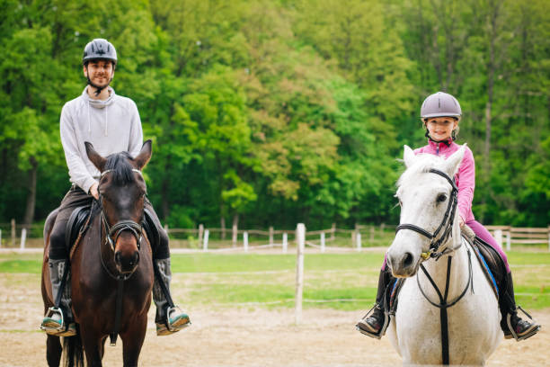 fratello insegna alla sorella a cavalcare un cavallo - teaching child horseback riding horse foto e immagini stock