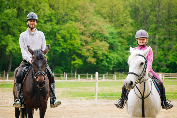 말을 타는 자매를 가르치는 형제 - teaching child horseback riding horse 뉴스 사진 이미지