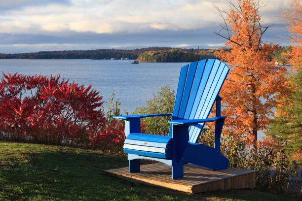 A giant Muskoka chair in the Muskoka region of Ontario, Canada. Image taken during prime fall colour. Lake Muskoka in background.