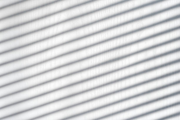 istock White wooden background with shadow from the blinds. Sunny day, interior 1186392743