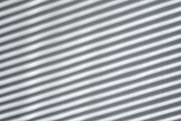istock White wooden background with shadow from the blinds. Sunny day, interior 1186392744