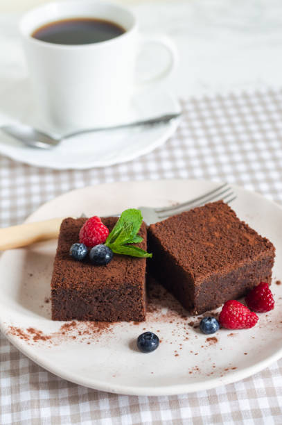 istock chocolate brownies cake decorated with mint and berries on a white plate 1186395300