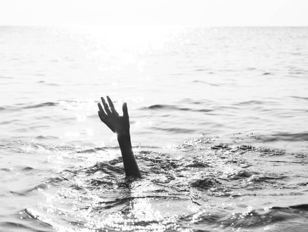 istock hand of man on the ocean with dramatic toned effect 1186395596