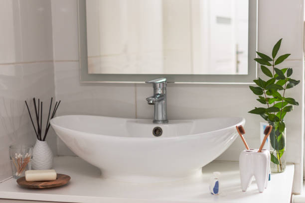 istock Bio-degradable, compostable bamboo toothbrushes in a tooth shape cup in a bathroom white interior. Green plant decor in background. 1186396229
