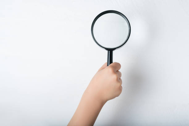 istock Magnifier in a children's hand on a white background. Close-up 1186396388