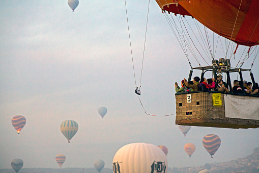 View of tourists watching and recording around on the hot air balloon in Cappadocia, Nevsehir, Turkey; eager to explore the gorgeous volcanic topography.