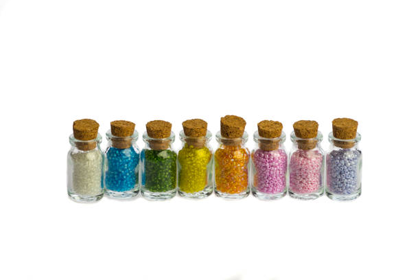 istock Little bottles in a row with colorful beads isolated on a white background, with copy space 1186397703