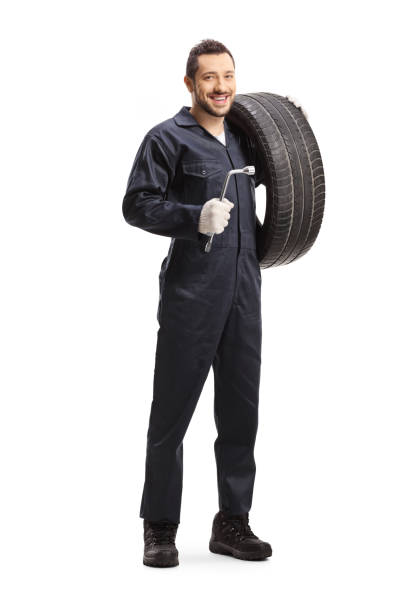 istock Mechanic holding a tire and a lug wrench 1186400843