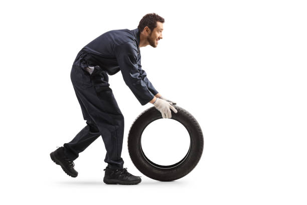 Repairman rolling a car tire