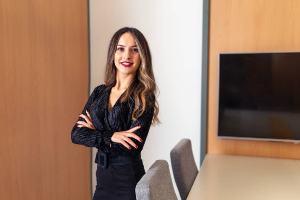 istock A smiling professional female executive stares forward with her standing arms tied. 1186401585