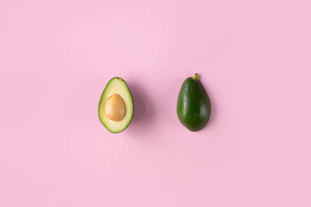 istock Avocado halves isolated on pink top view 1186401794