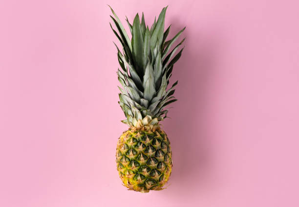 istock One fresh pineapple isolated on pink top view 1186401832