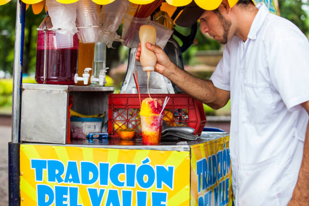 vendedor ambulante en la ciudad de cali en colombia preparando y vendiendo un hielo de agua dulce tradicional llamado cholado - valle del cauca fotografías e imágenes de stock