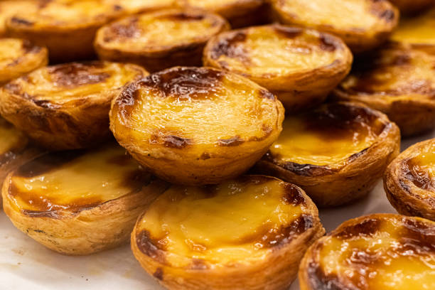 A pile of Portuguese custard tarts Lots of "pastéis de nata", the traditional Portuguese custard tarts, displayed on a pile pasteis de belem stock pictures, royalty-free photos & images