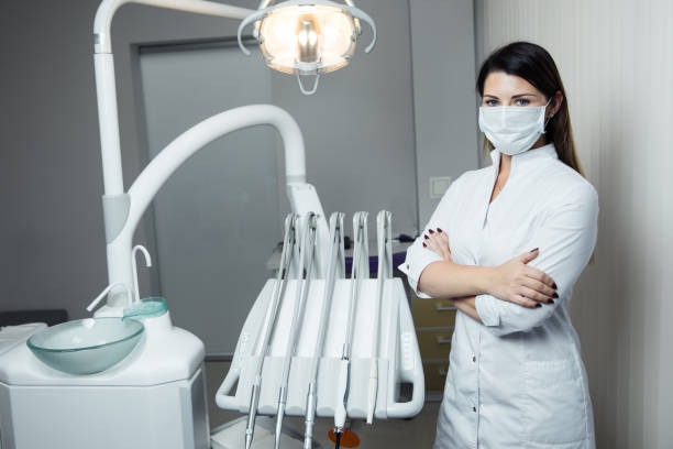Portrait of female dentist .She standing in her dentist office. Female dentist wearing a white robe stock photo