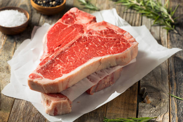 raw red grass fed t bone steak - porterhouse steak photos et images de collection