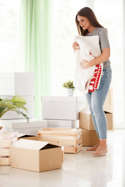 istock Young woman packing a blanket for moving house 1186414532