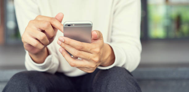 istock close up young man hand holding smartphone device for searching internet website or playing on application in relaxing time , millennial lifestyle people concept 1186414994