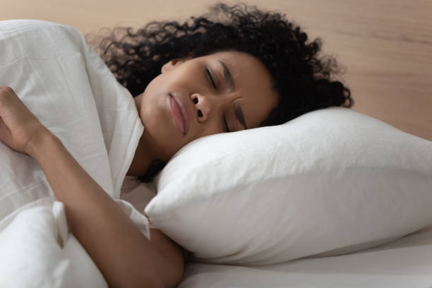 istock African woman lying in bed has nightmares sleeps bad 1186418404