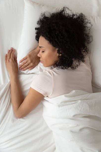 above top vertical view african woman sleeping in bed - sheet sleeping women bed imagens e fotografias de stock