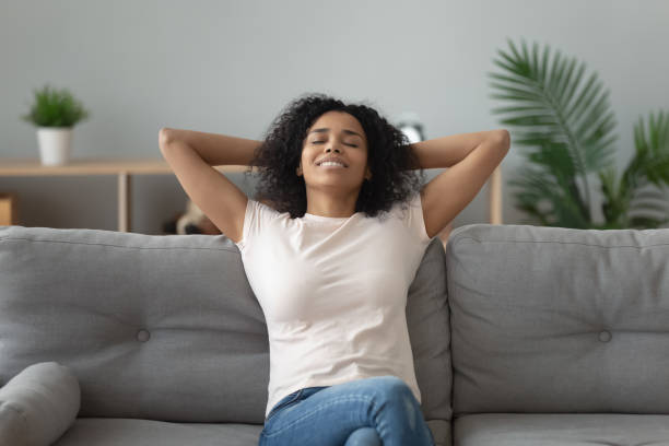 istock Serene african woman leaned on couch resting at home 1186418474