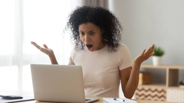 Amazed shocked african woman open mouth gawp at computer screen Amazed confused frown african woman open mouth gawp look at computer screen, 30s female received shocking news, having big serious problems unsaved document, critical error, need repair master concept gawp stock pictures, royalty-free photos & images
