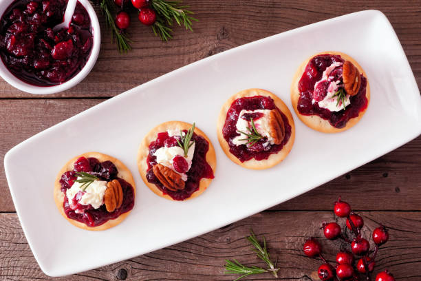 istock Holiday appetizers with cranberries, goat cheese and pecans on a serving plate, top view table scene on wood 1186419321