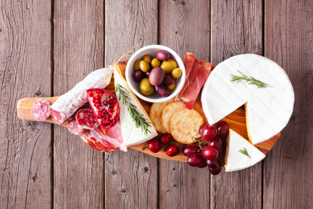 istock Serving board of assorted meats, cheeses and appetizers, overhead view on rustic wood 1186420045