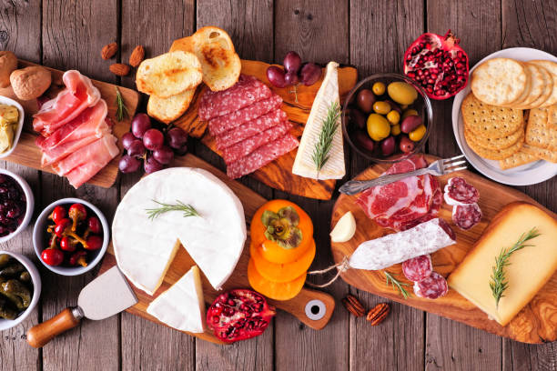 charcuterie tablas de carnes variadas, quesos y aperitivos, escena de mesa de vista superior en madera rústica - comida francesa fotos fotografías e imágenes de stock