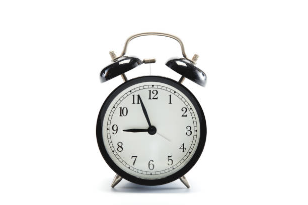 istock Close up black vintage alarm clock on white background 1186423786