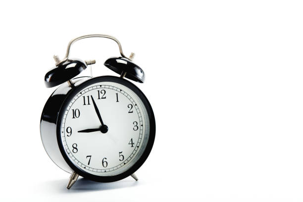istock Close up black vintage alarm clock on white background 1186423796