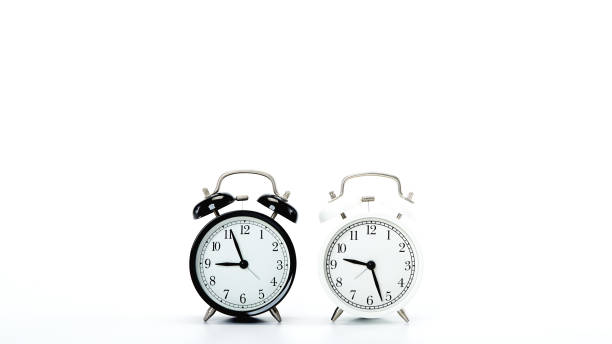 istock Black vintage alarm clock and White clock on white background 1186423797