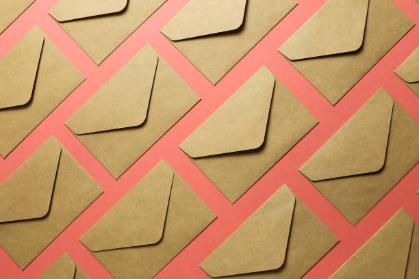 istock Kraft brown paper envelopes on pink background 1186423878