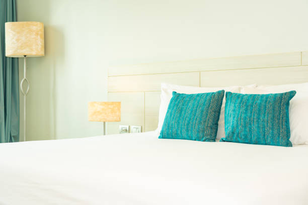 istock Pillow and blanket on bed with light lamp decoration interior 1186428670