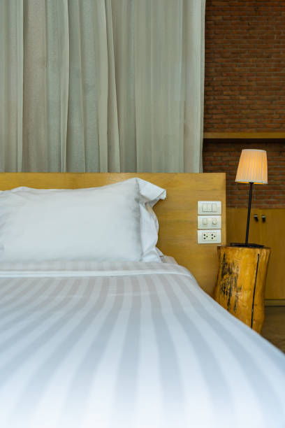 istock Pillow and blanket on bed with light lamp decoration interior 1186428672