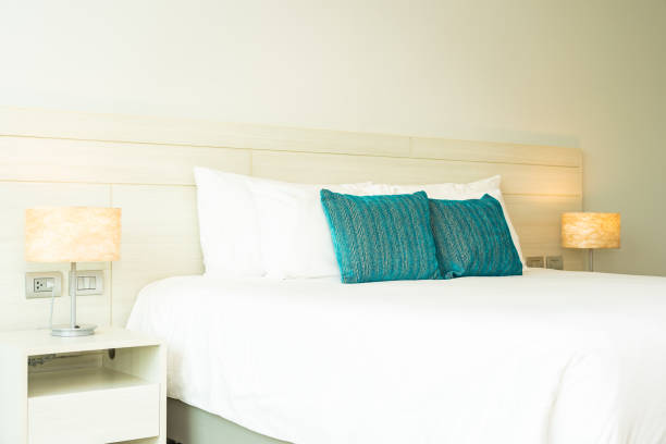 istock Pillow and blanket on bed with light lamp decoration interior 1186428745