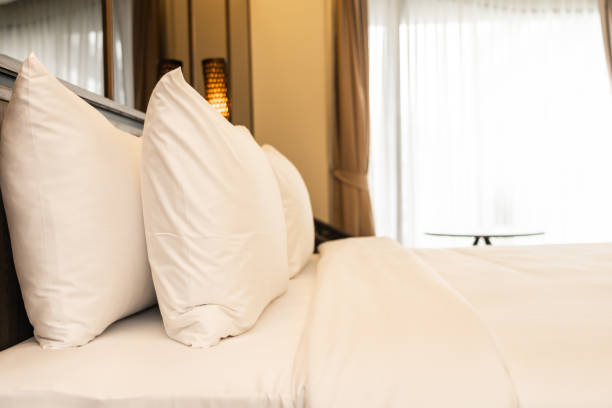 istock Pillow and blanket on bed with light lamp decoration interior 1186429490