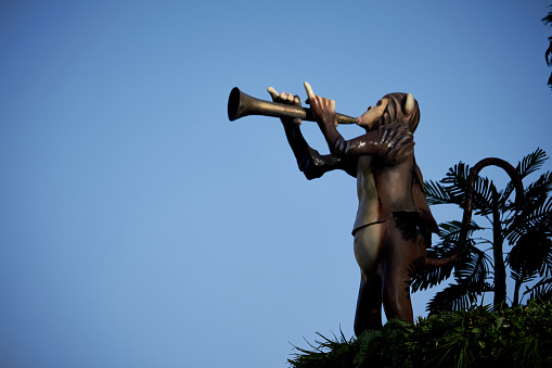 Kharkiv, Ukraine - October 14, 2019: Ape plays on trumpet, city park decoration among rocks