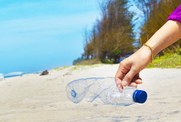 istock Hand holding plastic water bottles wasted against blue sky background. Illustration concept environmental, ecological problem. 1186431229