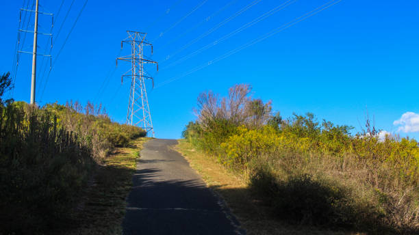 up hill trail e high voltage electric power line tower in cima, bella giornata di sole di nizza, cieli blu chiaro in south carolina - epg foto e immagini stock