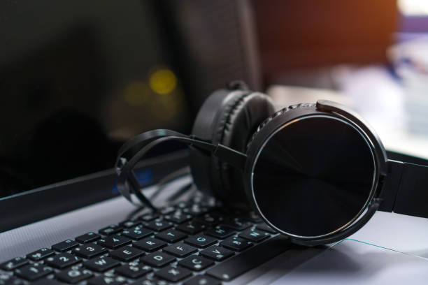 istock Headset or headphone on laptop keyboard for helpline customer on communication and hotline support call center service. voip digital phone for helpdesk in business office 1186454334